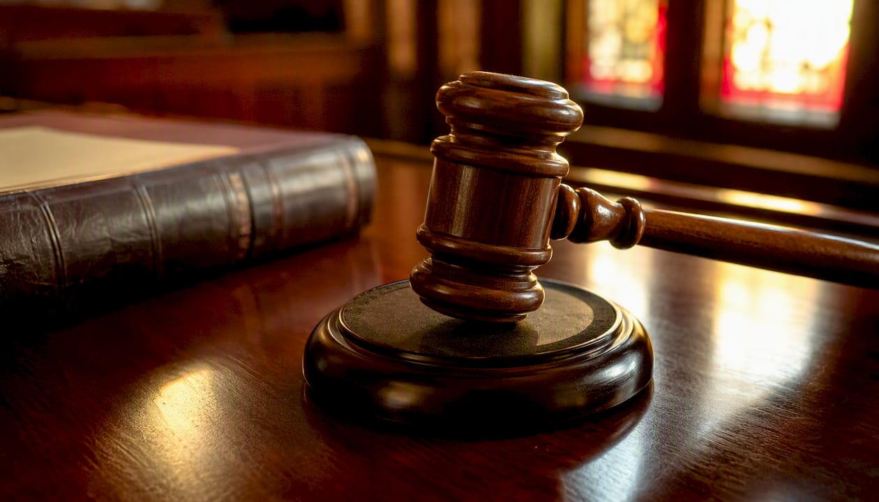 Judge's gavel striking sound block in courtroom