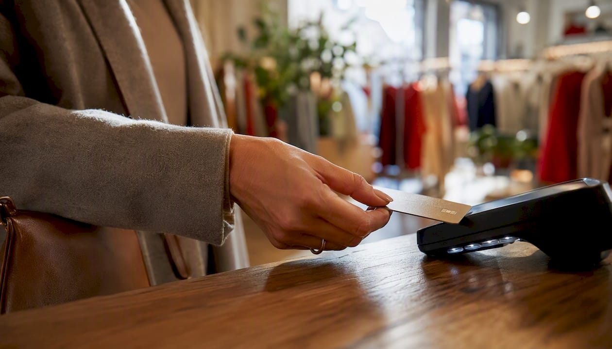 Hand tapping credit card on payment terminal