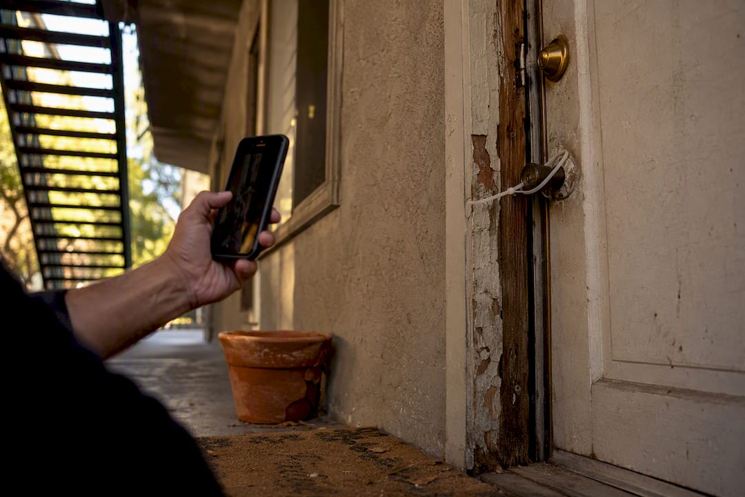 Tenant photographing broken apartment door lock
