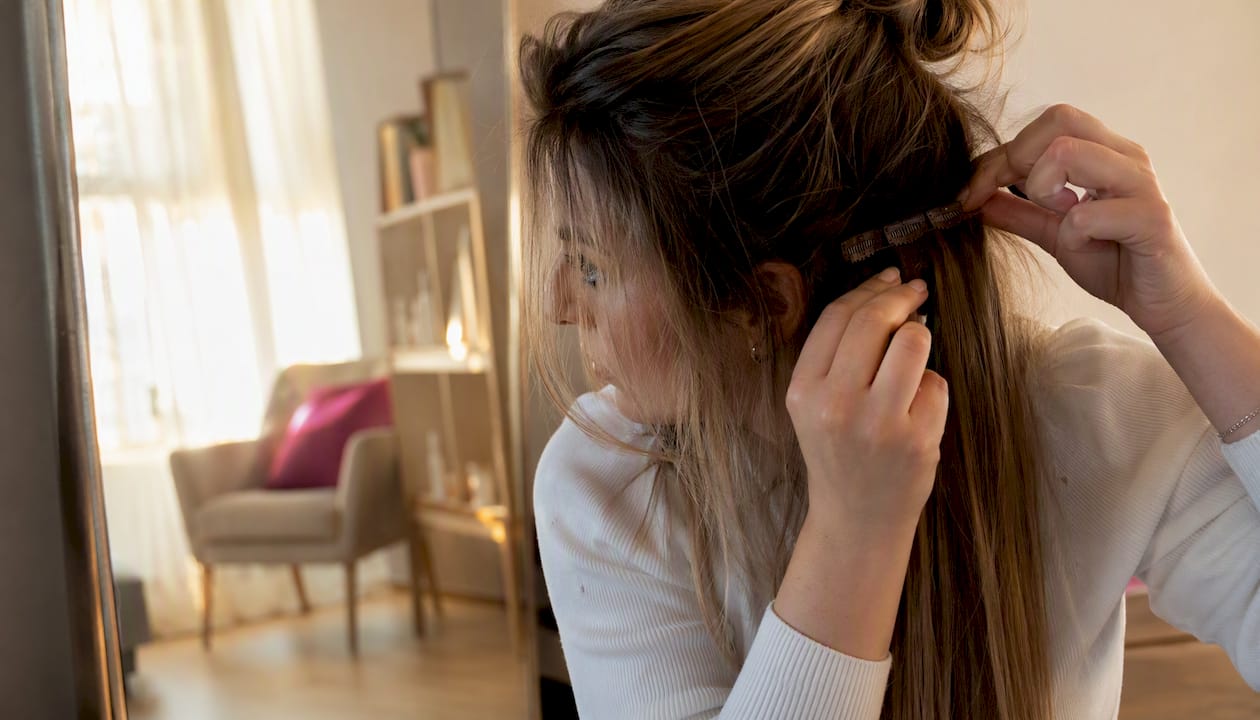Woman applying clip-in hair extensions