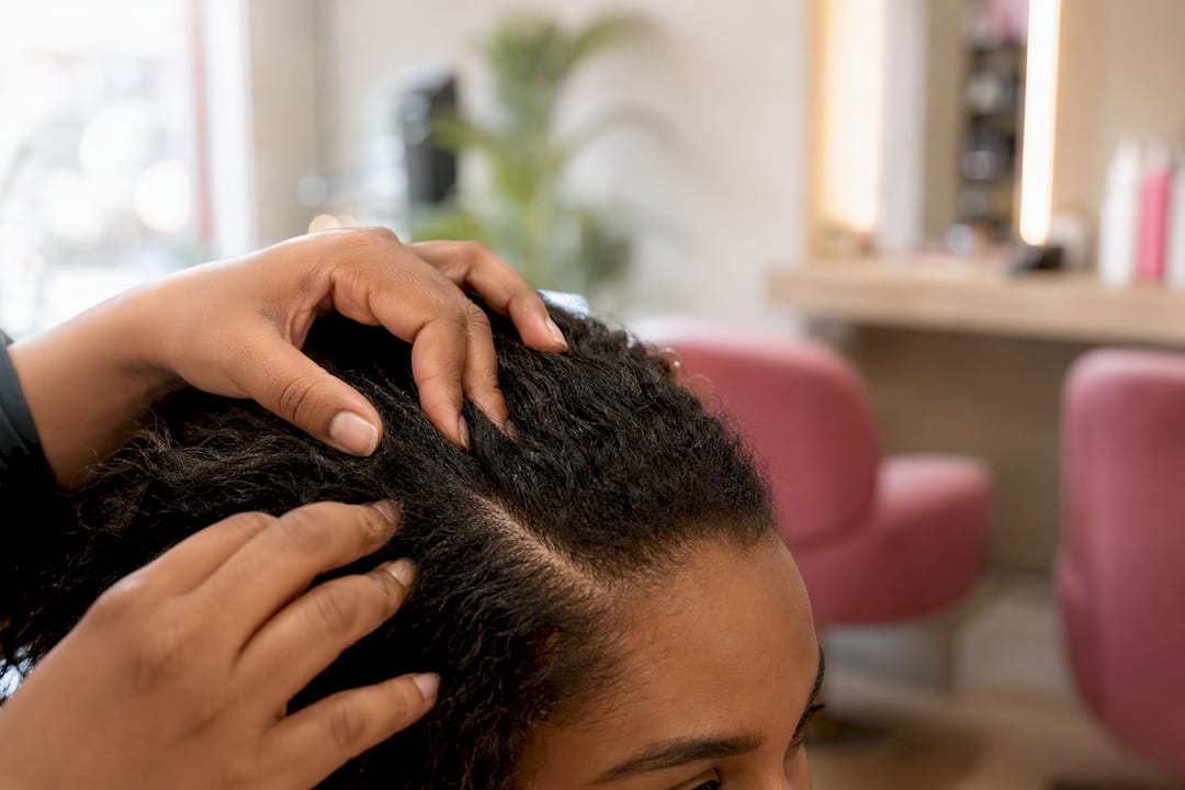 Close-up of stylist parting hair showing scalp tension