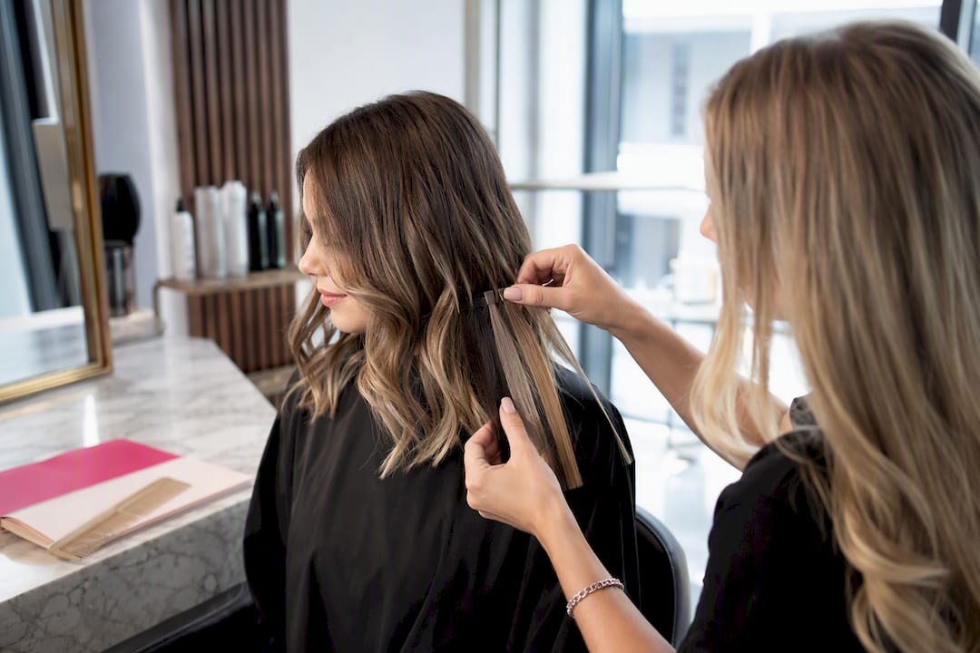 Colorist comparing highlighted mid-length hair