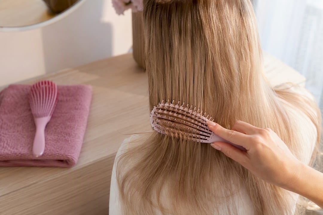 Hand brushing hair extension lengths gently