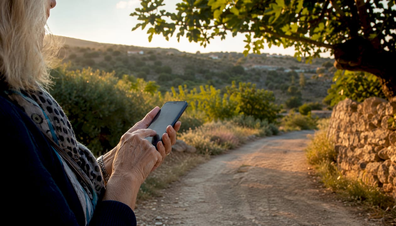 Hands holding phone showing rural map in Sicily