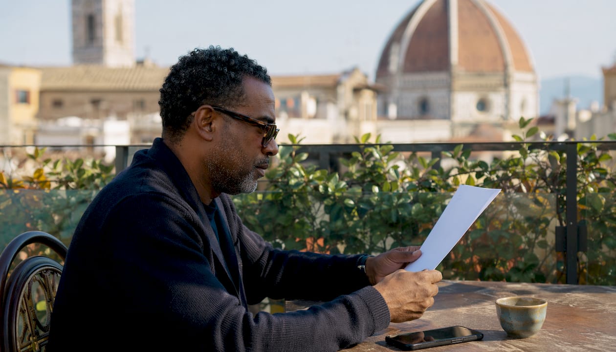 Man at café reviewing visa eligibility papers