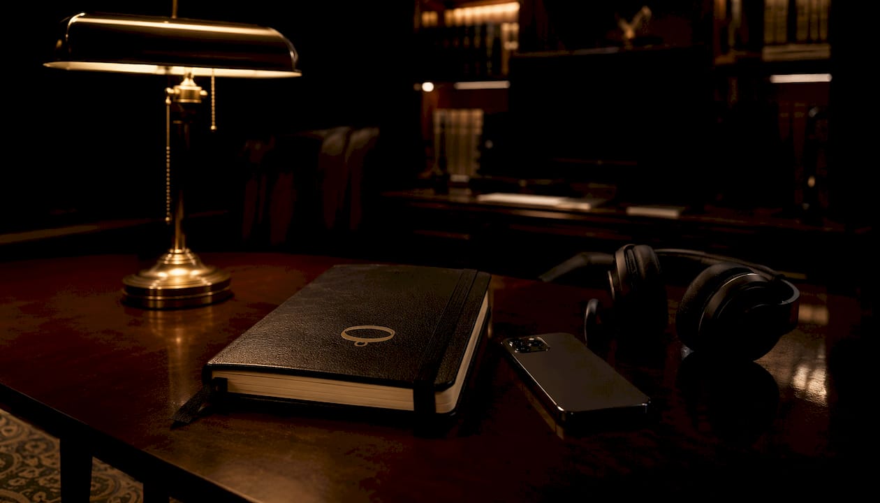 Close view of intimate desk with dark tech and journal