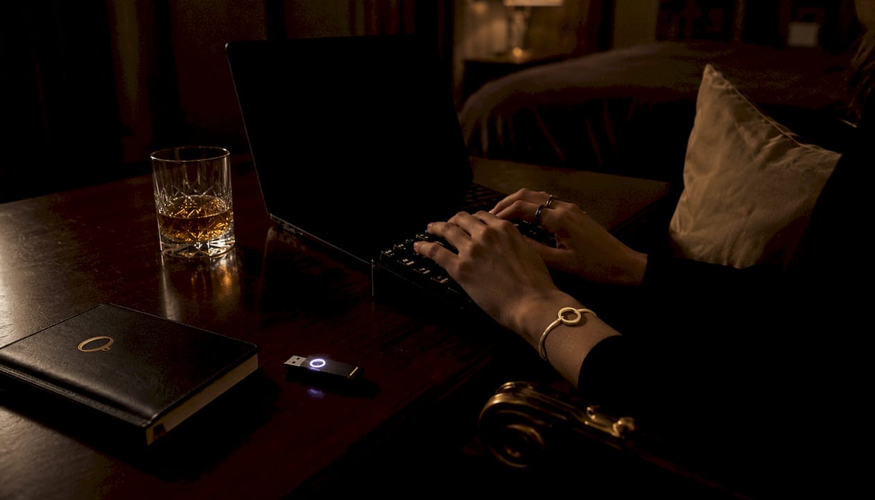 Hands typing on dark laptop in intimate office