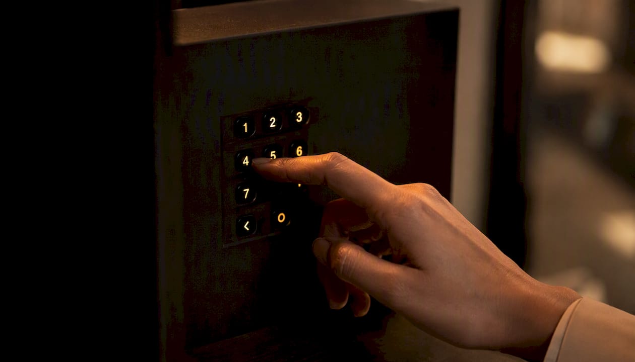 Hand entering PIN on secure device keypad