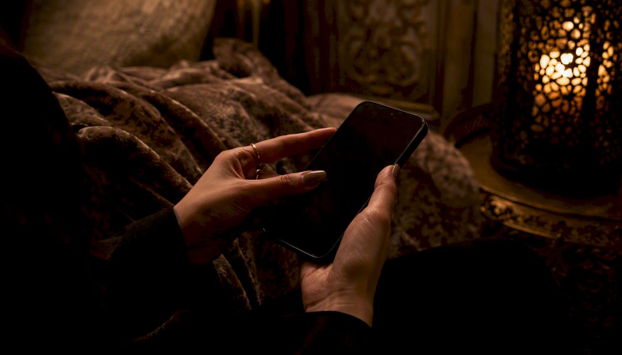 Hands entering PIN on smartphone in warm intimate setting