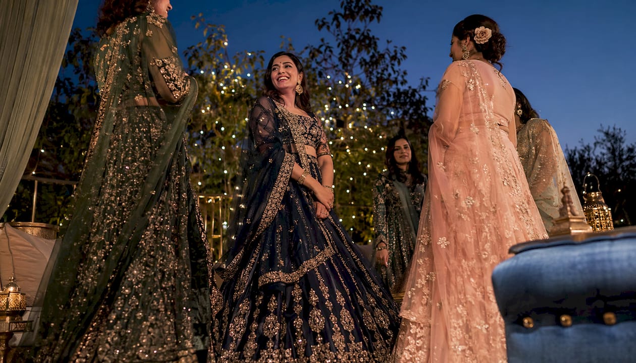 Group of women in embellished lehengas outdoors