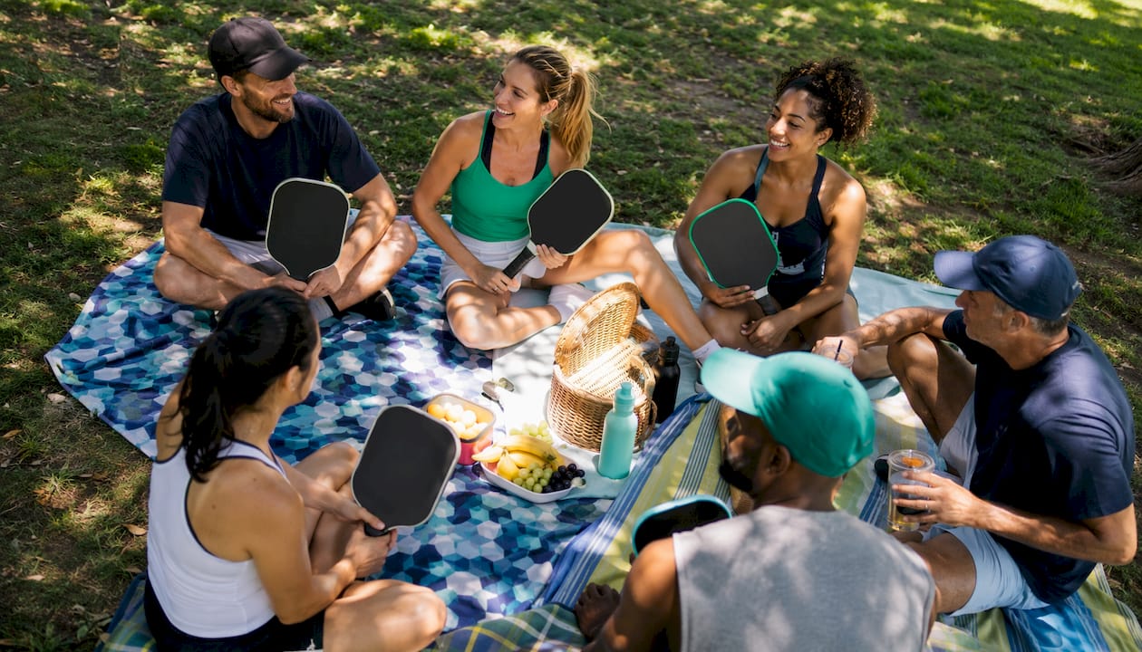 Social group of pickleball players chatting outdoors