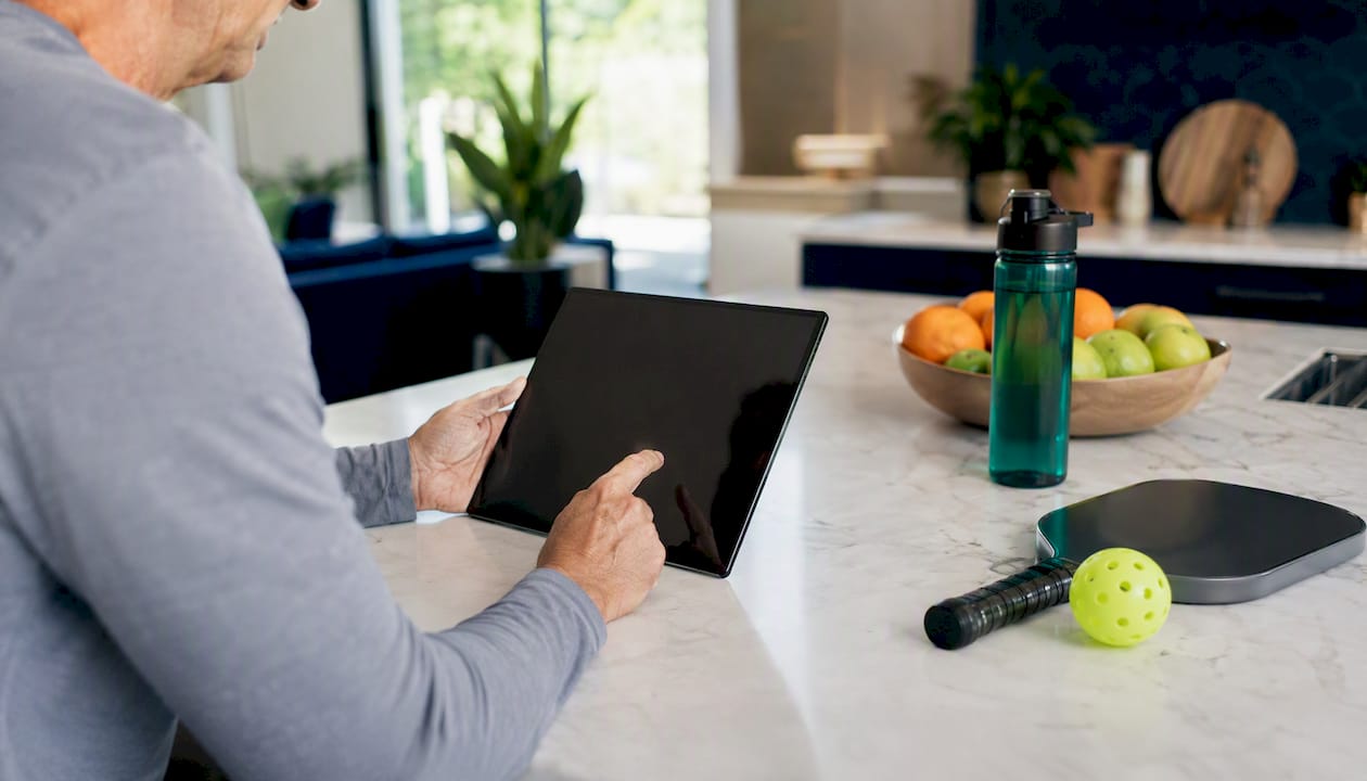 Hands registering for pickleball league on tablet