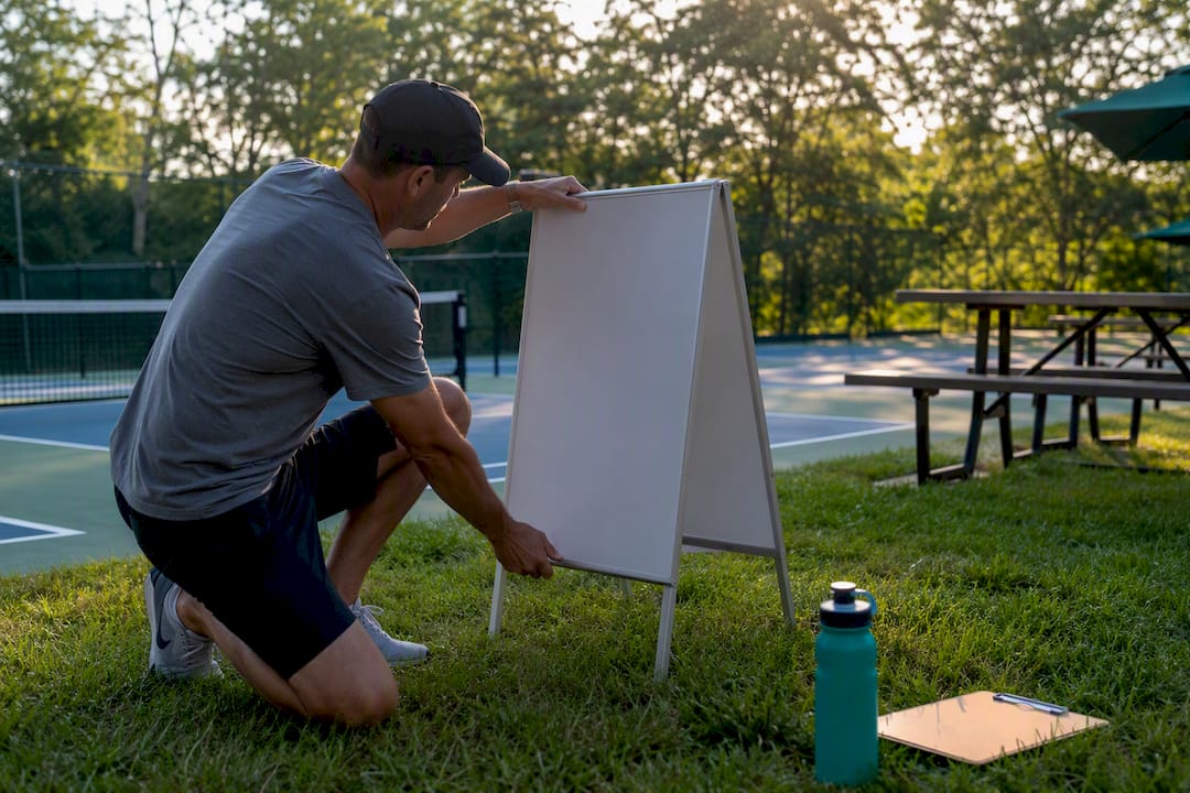 League manager setting up blank signboard at court