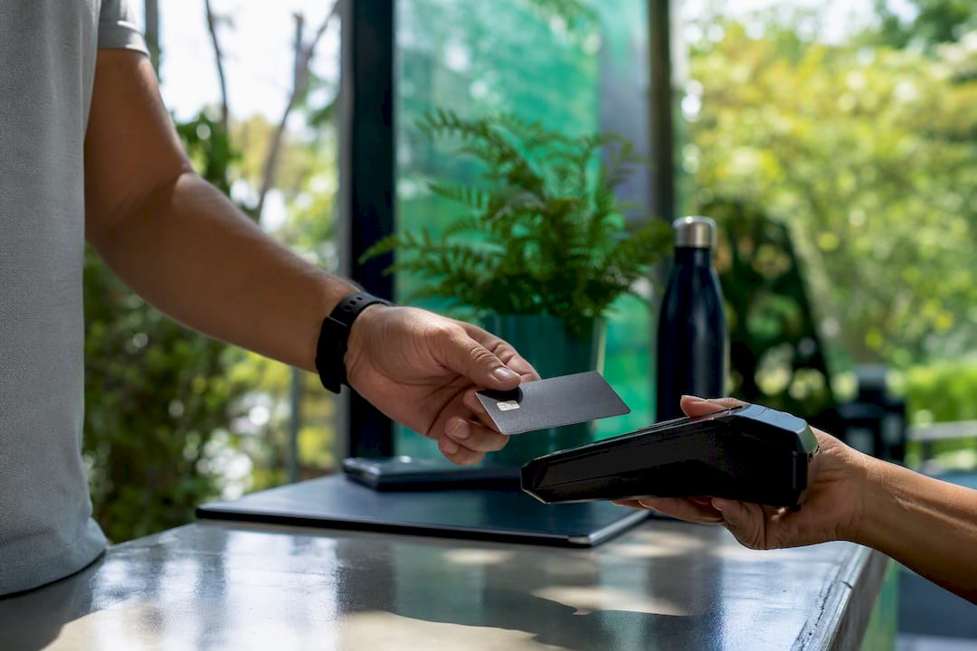 Hands holding credit card near payment terminal