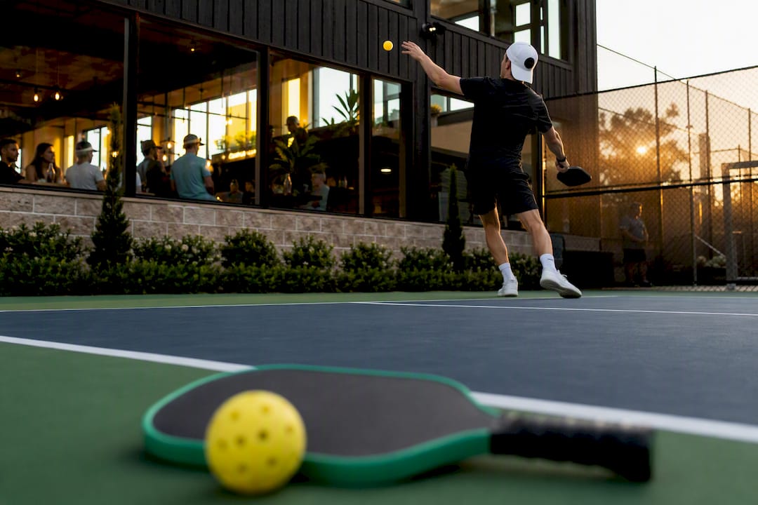 Indoor outdoor pickleball court with player serving