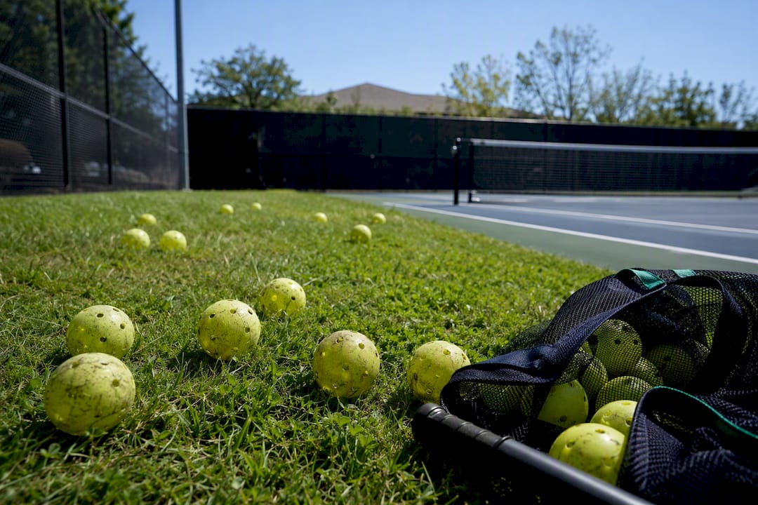 Worn pickleball balls on outdoor court