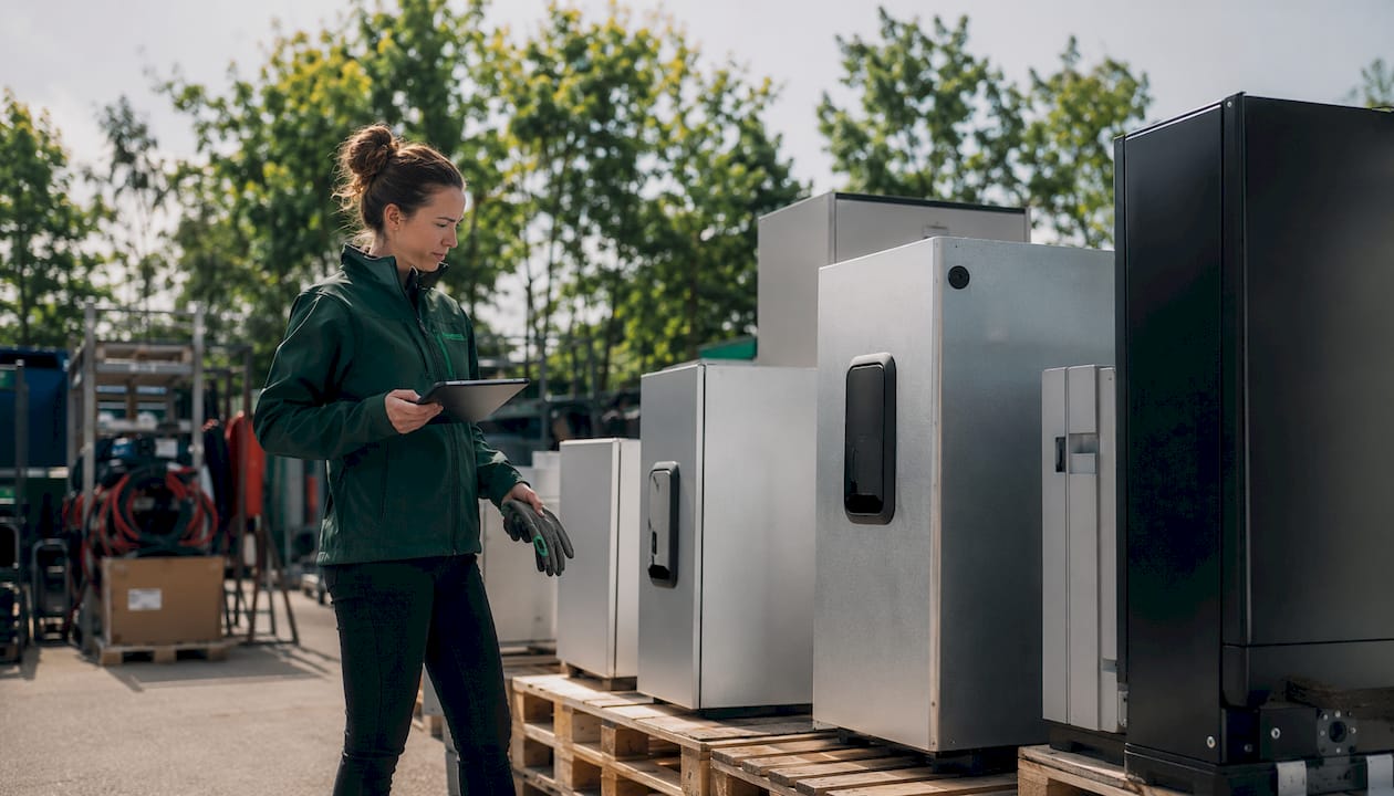Electrician reviews EV charger enclosure options in warehouse
