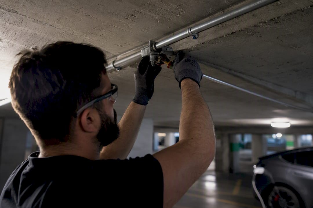Electrician wiring conduit for condo EV charger