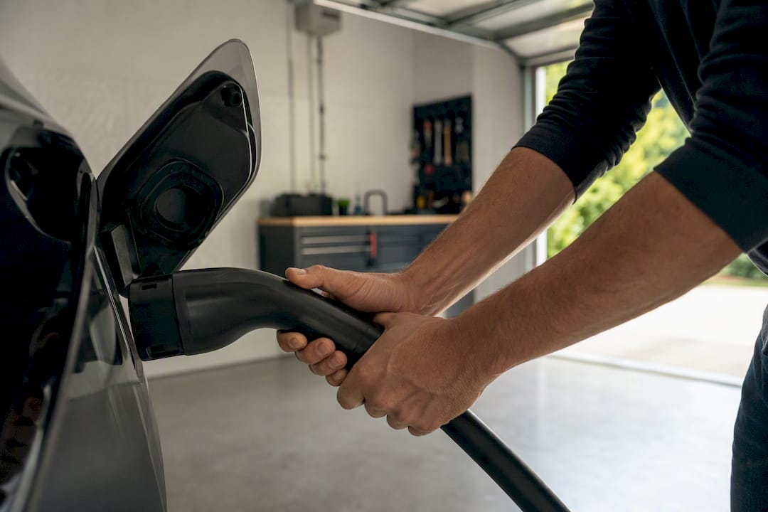 Electrician plugging EV charger into vehicle port