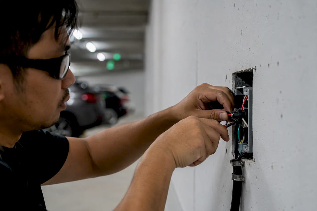Electrician wiring conduit for condo EV charger
