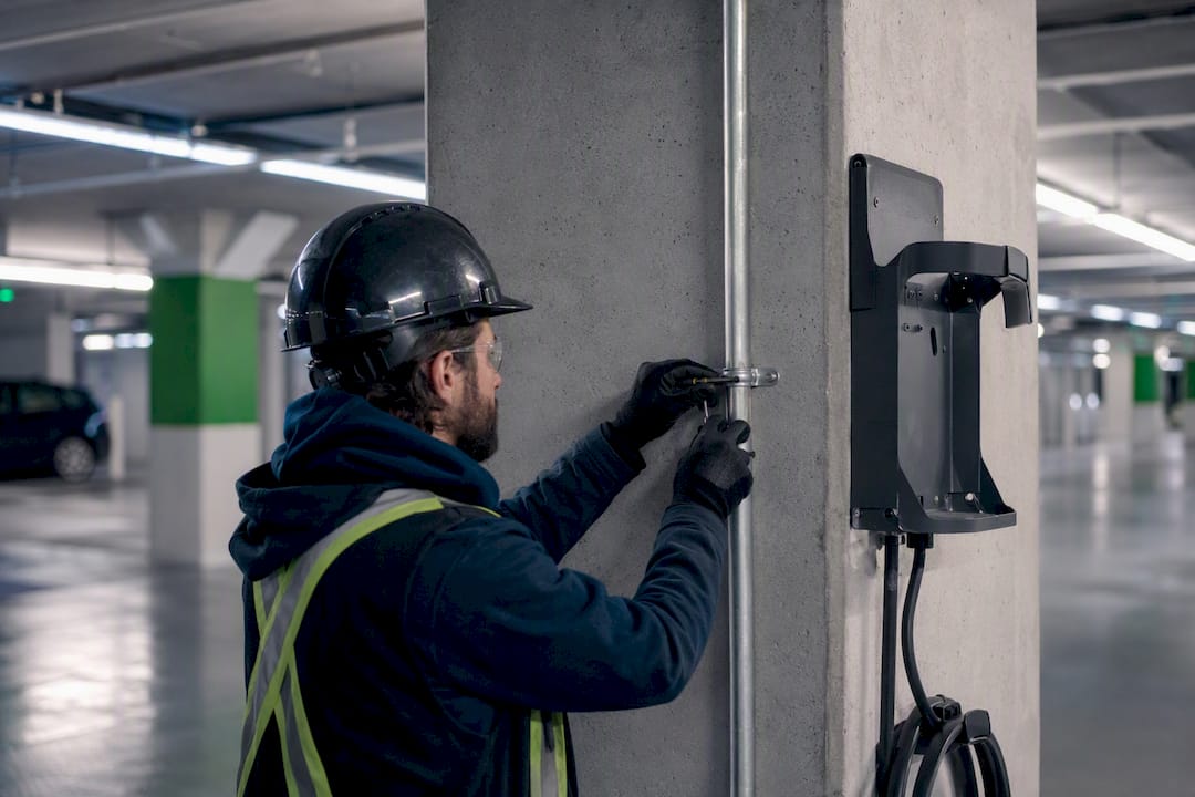 Electrician wiring conduit for EV charger in condo garage