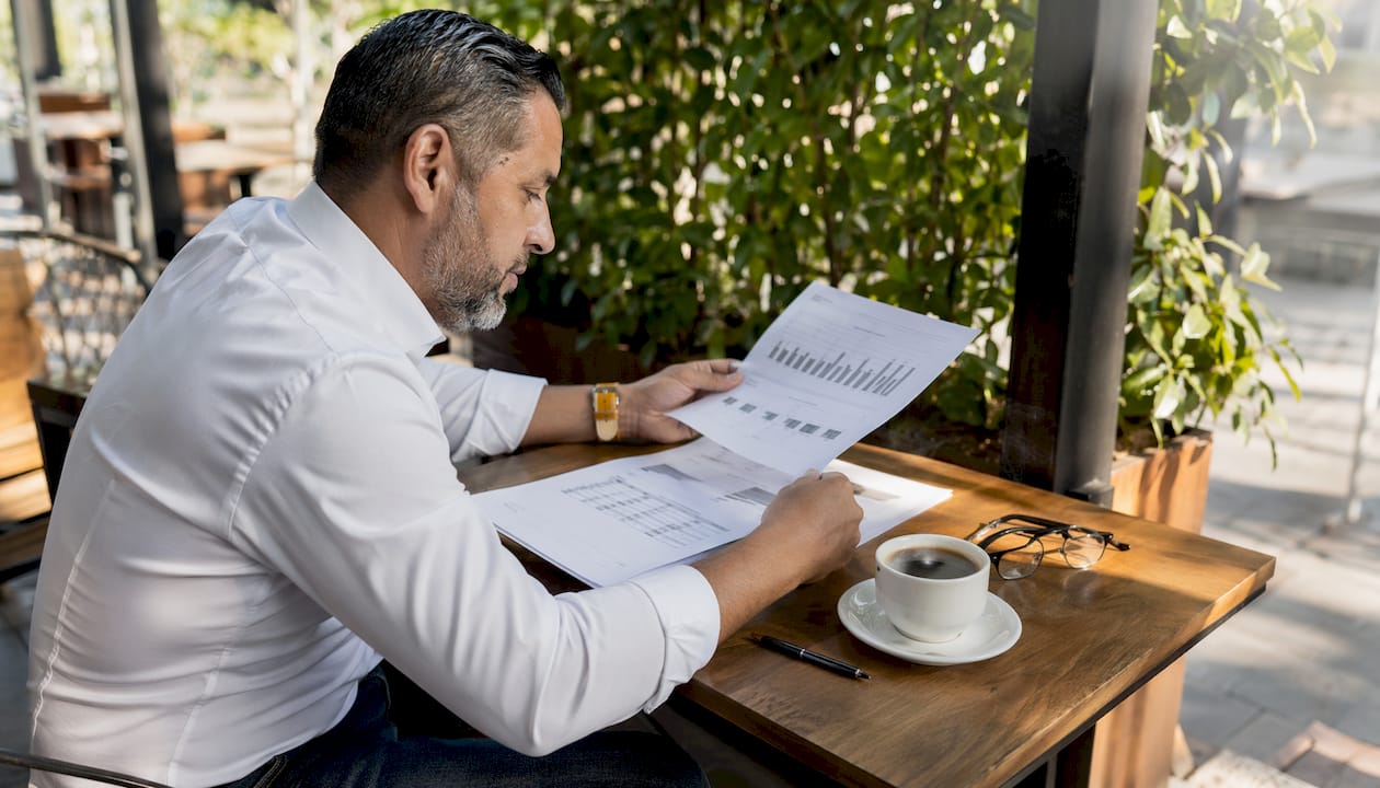 Hands arranging real estate cash flow charts on table
