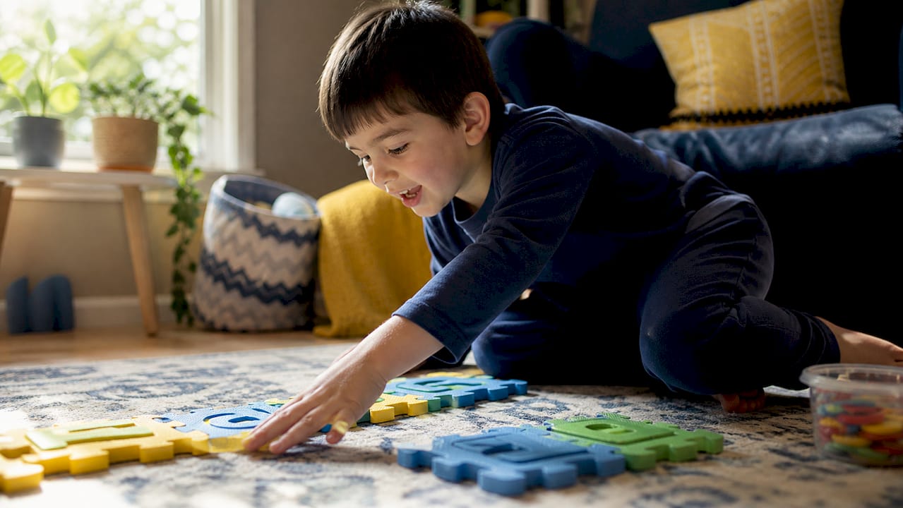 Child playing with colorful wooden letter blocks