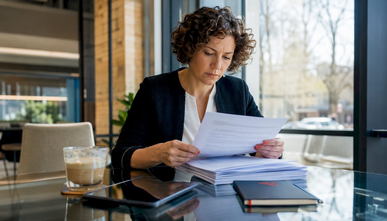 Woman reviewing refund policy documents in café