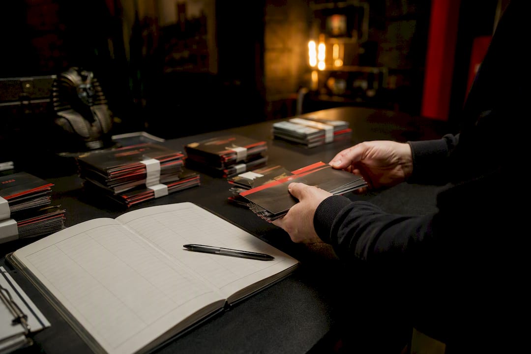 Hands managing and sorting gift card batches and ledger