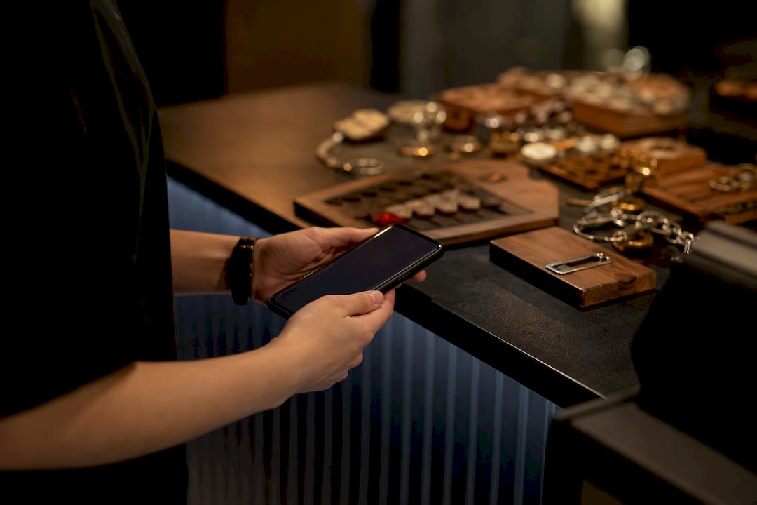 Hands holding smartphone near escape room counter