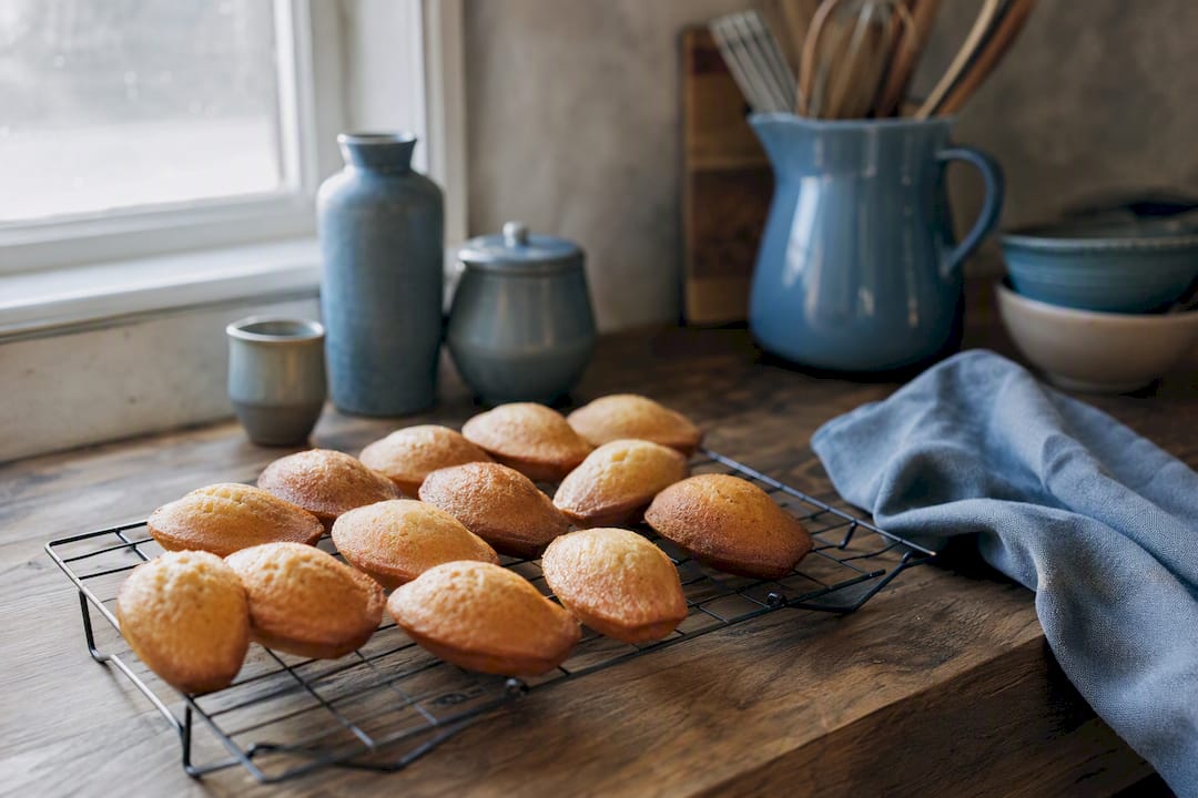 Madeleines au citron fraîchement sorties du four, en train de refroidir sur une grille