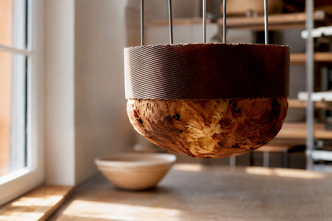 Panettone refroidissant la tête en bas sur des brochettes