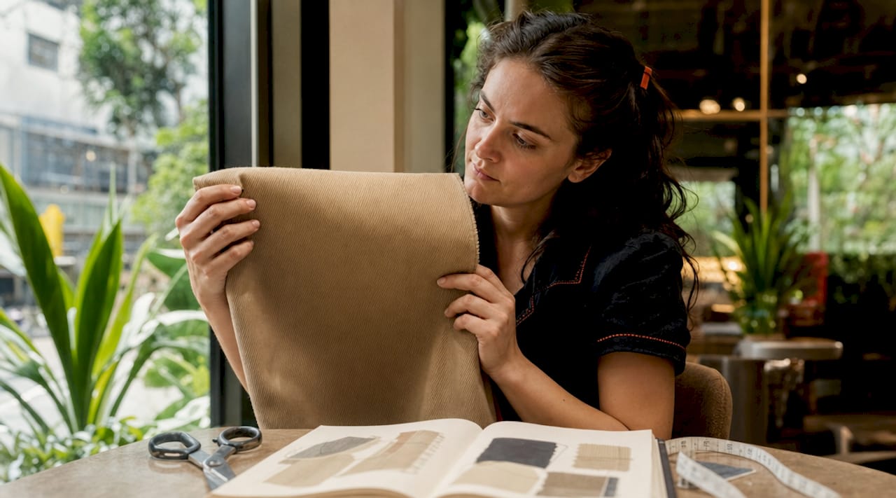 Designer examining cotton twill fabric swatch