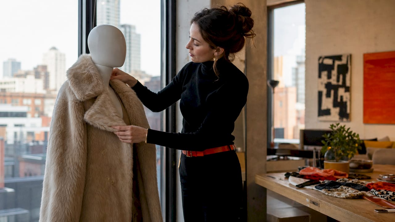 Woman styling faux fur coat in studio