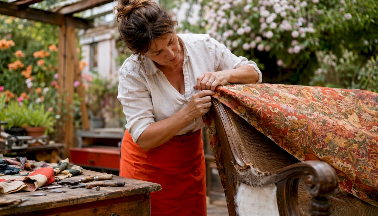Upholsterer stretching fabric on chair frame