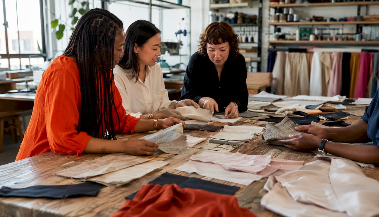 Hands inspecting diverse fabric samples