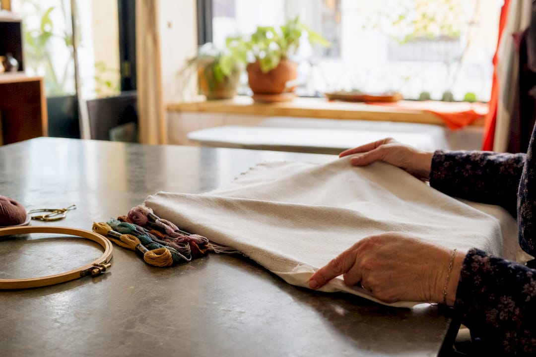 Hands preparing twill fabric for embroidery