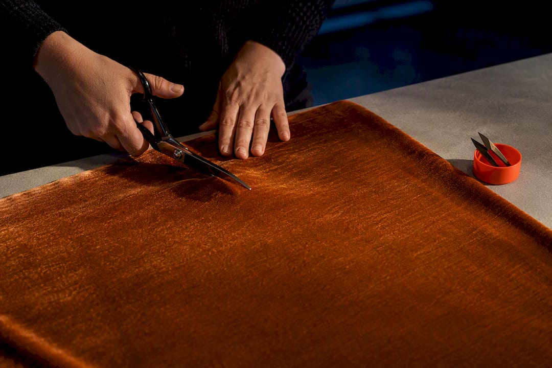 Hands cutting velvet in one nap direction