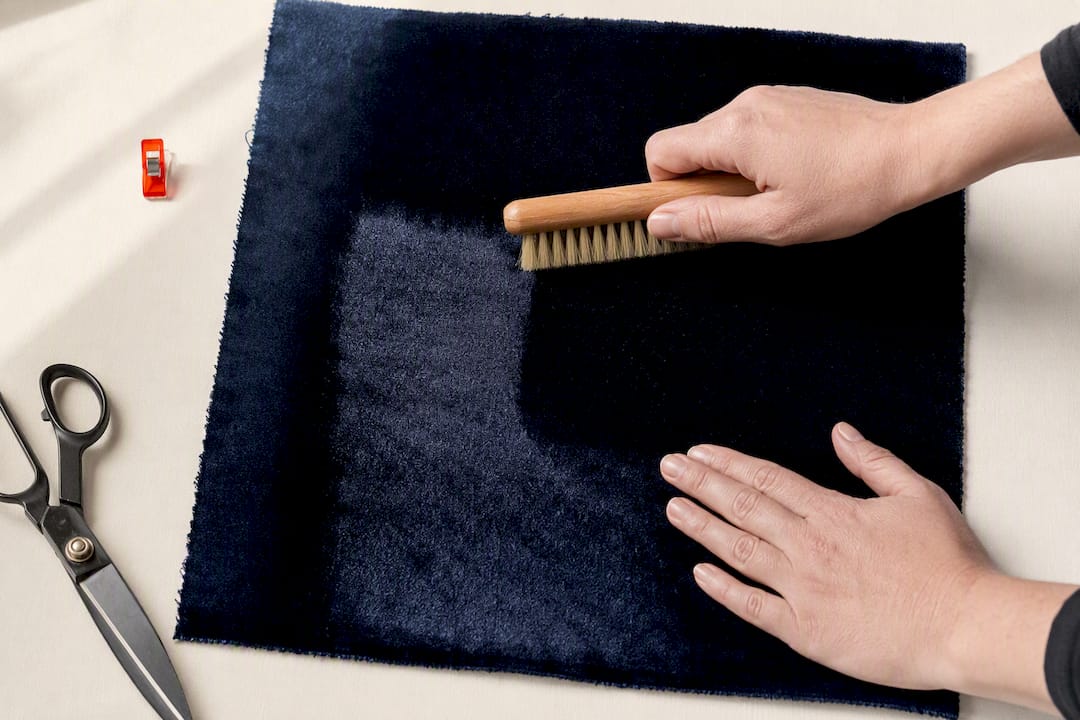 Hand brushing velvet to inspect nap consistency