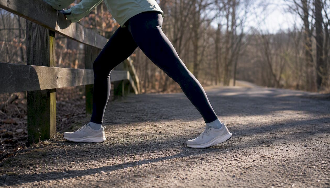 Runner stretching calves outdoors in winter