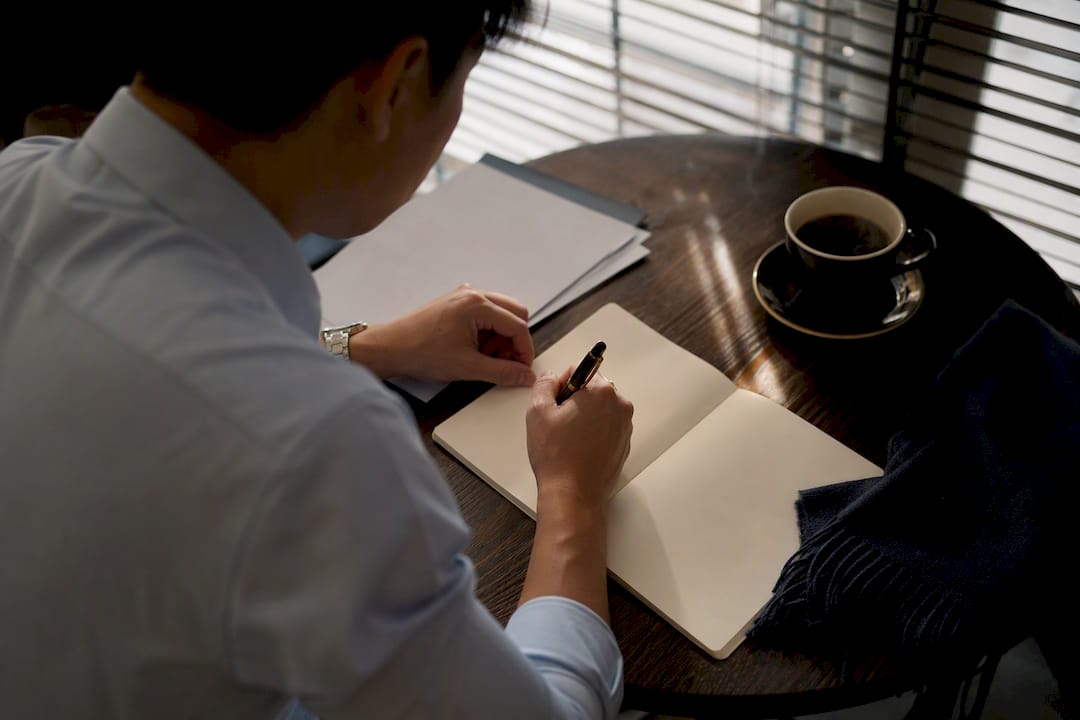 Agent writing interview questions with coffee nearby