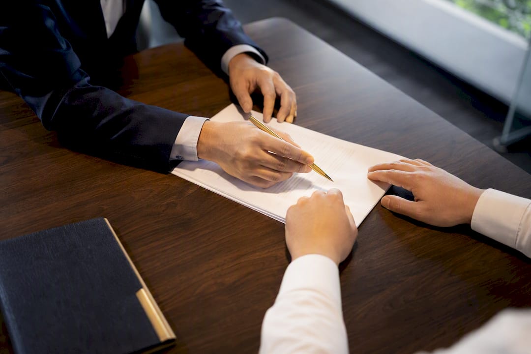 Hands reviewing an estate agency agreement