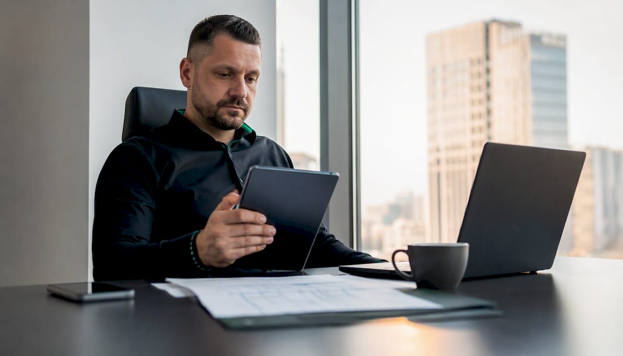 Im Büro kontrolliert der Sicherheitsdisponent den aktuellen Schichtplan am Computer.