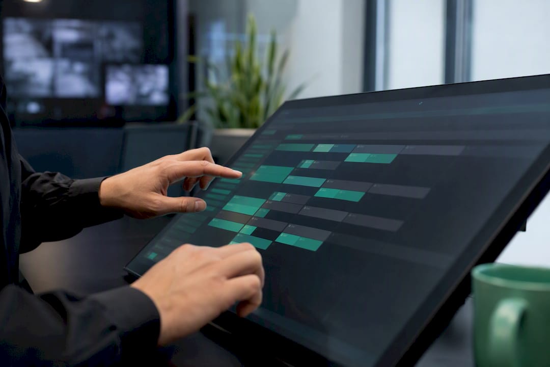 Hände verwalten Schichtplan auf einem digitalen Touchscreen