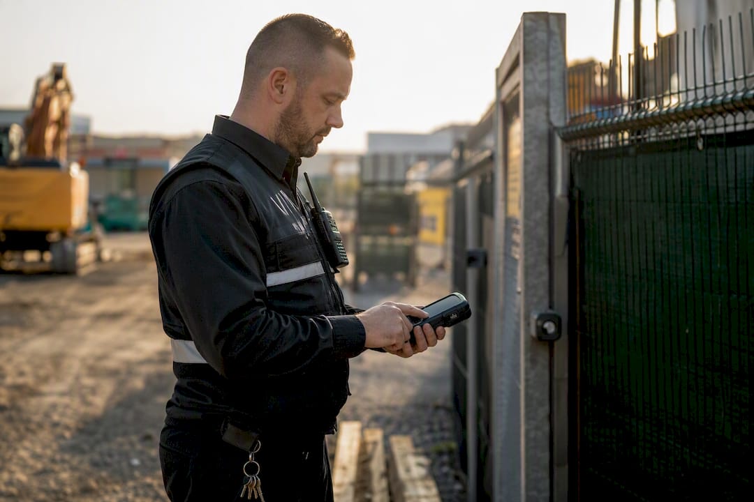 Wächter drückt auf ein tragbares GPS-Gerät zur Dienstanmeldung