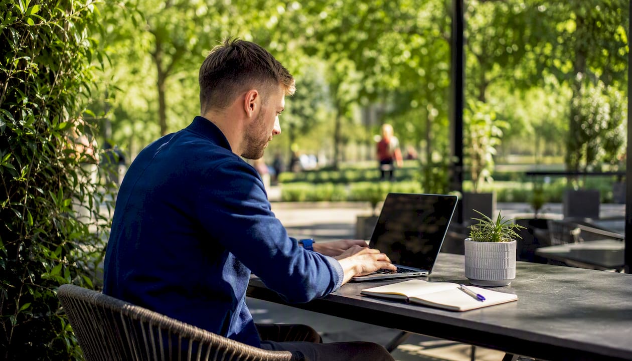 Business owner using laptop in modern UK co-working space