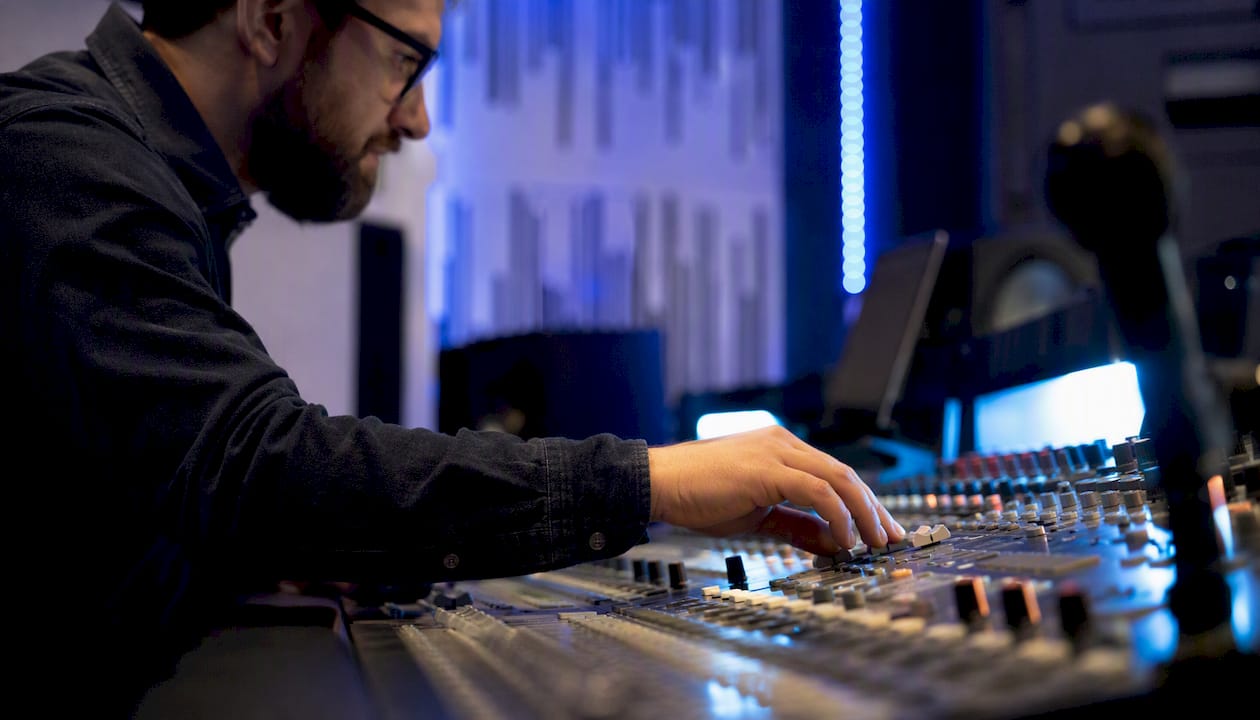 Audio engineer adjusting mixer console