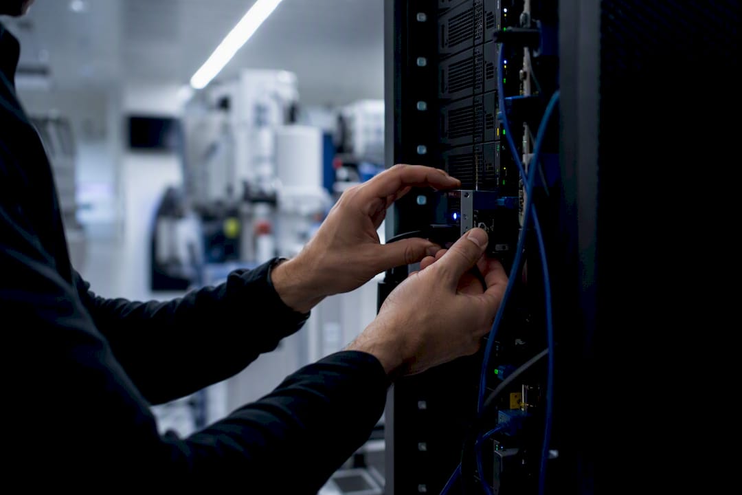 Hands adjusting tracking device in server room