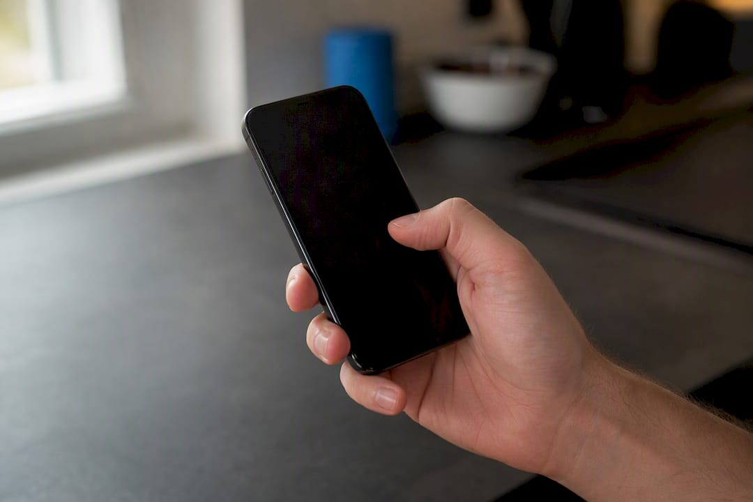 Hand holding smartphone above screen edge