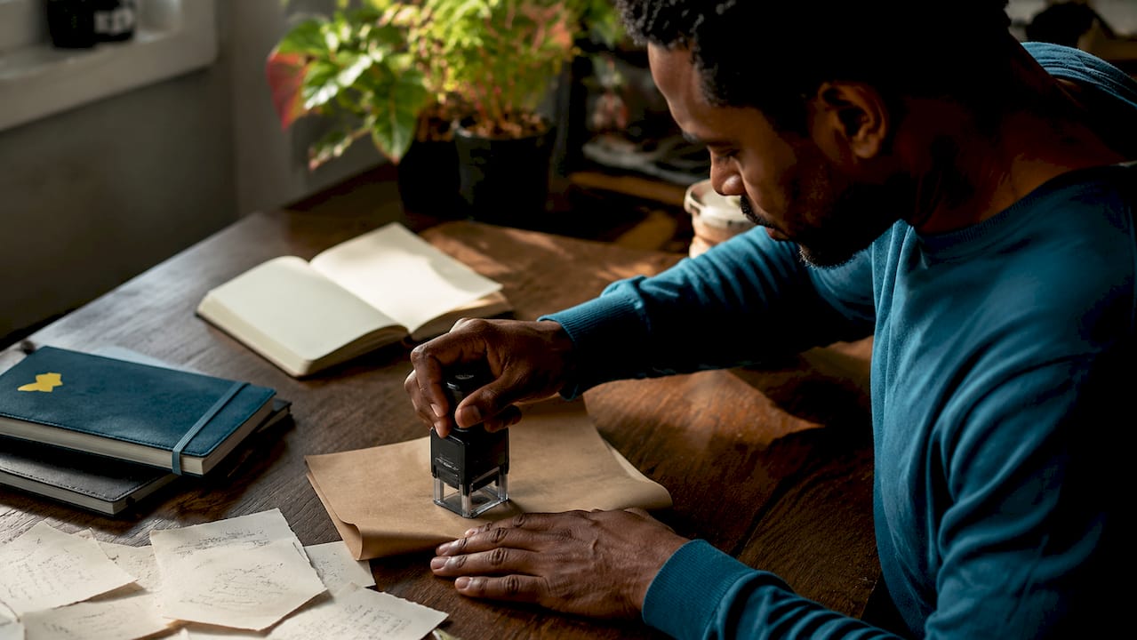 Hands pressing professional self-inking stamp